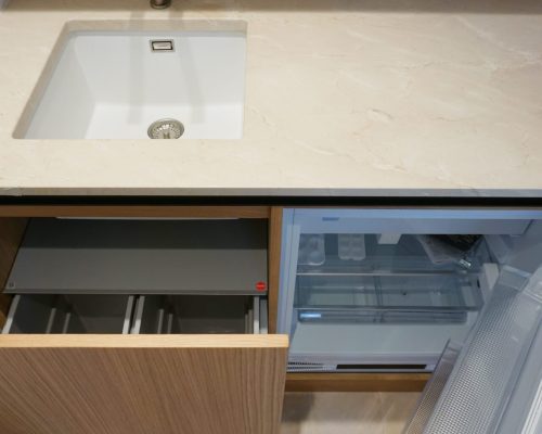 Bancada em mármore creme com lixeiras extratíveis encastradas