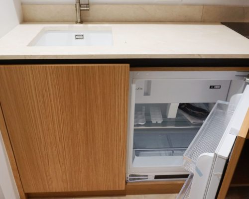 Mini frigorífico encastrado sob bancada de mármore creme em carvalho