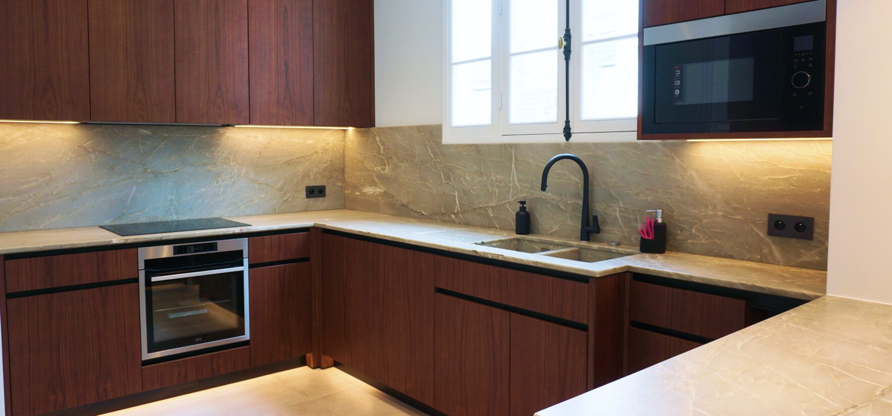 Móveis de cozinha por medida Templo Cozinha moderna com móveis por medida em madeira de design escandinavo e bancada de pedra mármore clara com pia de inox, em um apartamento.