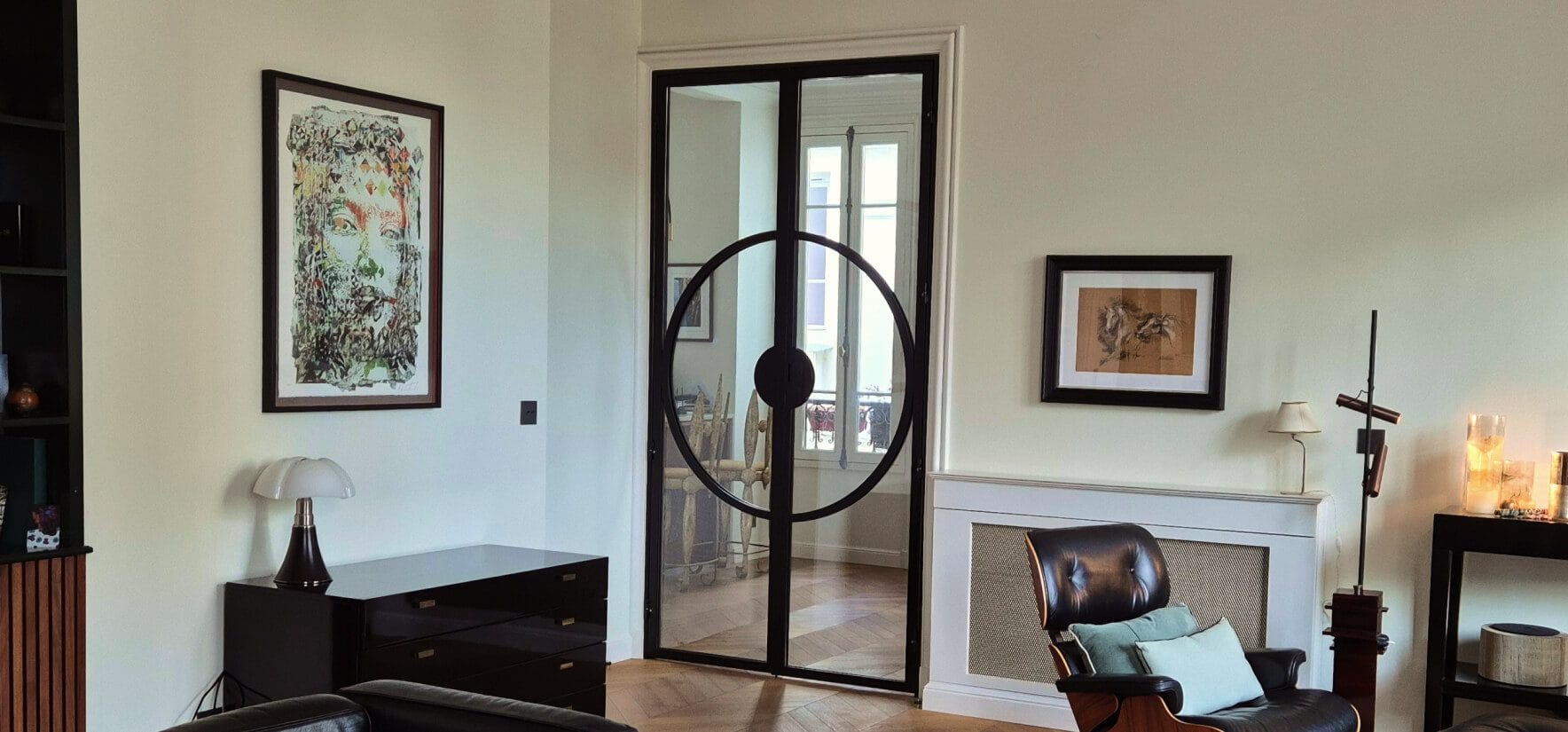 Porta dupla em ferro preto e vidro com design circular enquadrada no salão em Paris