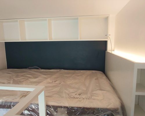 Cama mezzanine superior com colchão e painel de cabeceira em tom azul