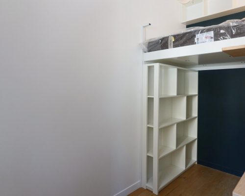 Estante modular branca para livros integrada sob a estrutura da cama mezzanine